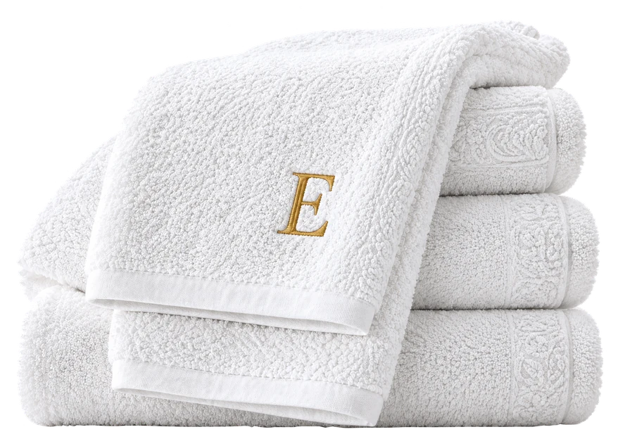 Stack of white towels with an embroidered monogram